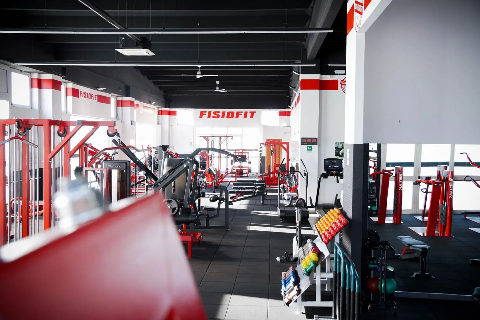 Area bodybuilding attrezzata con manubri e bilancieri alla Fisiofit